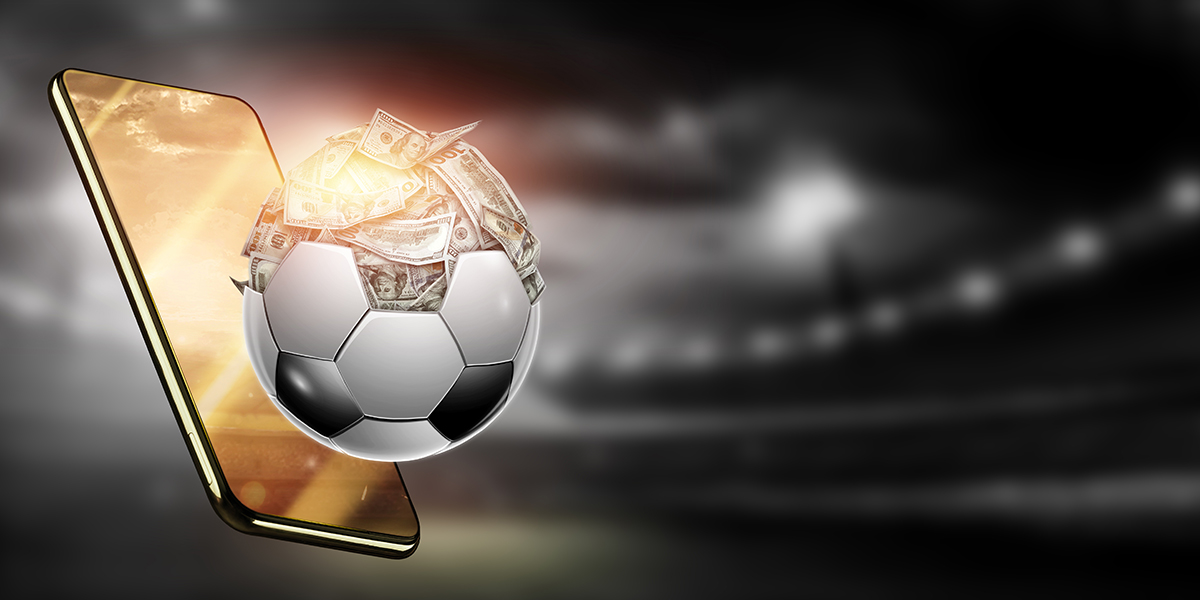 Imagem de uma bola de futebol "saindo" de um smartphone, representando as apostas esportivas online que foram regulamentadas no Brasil.